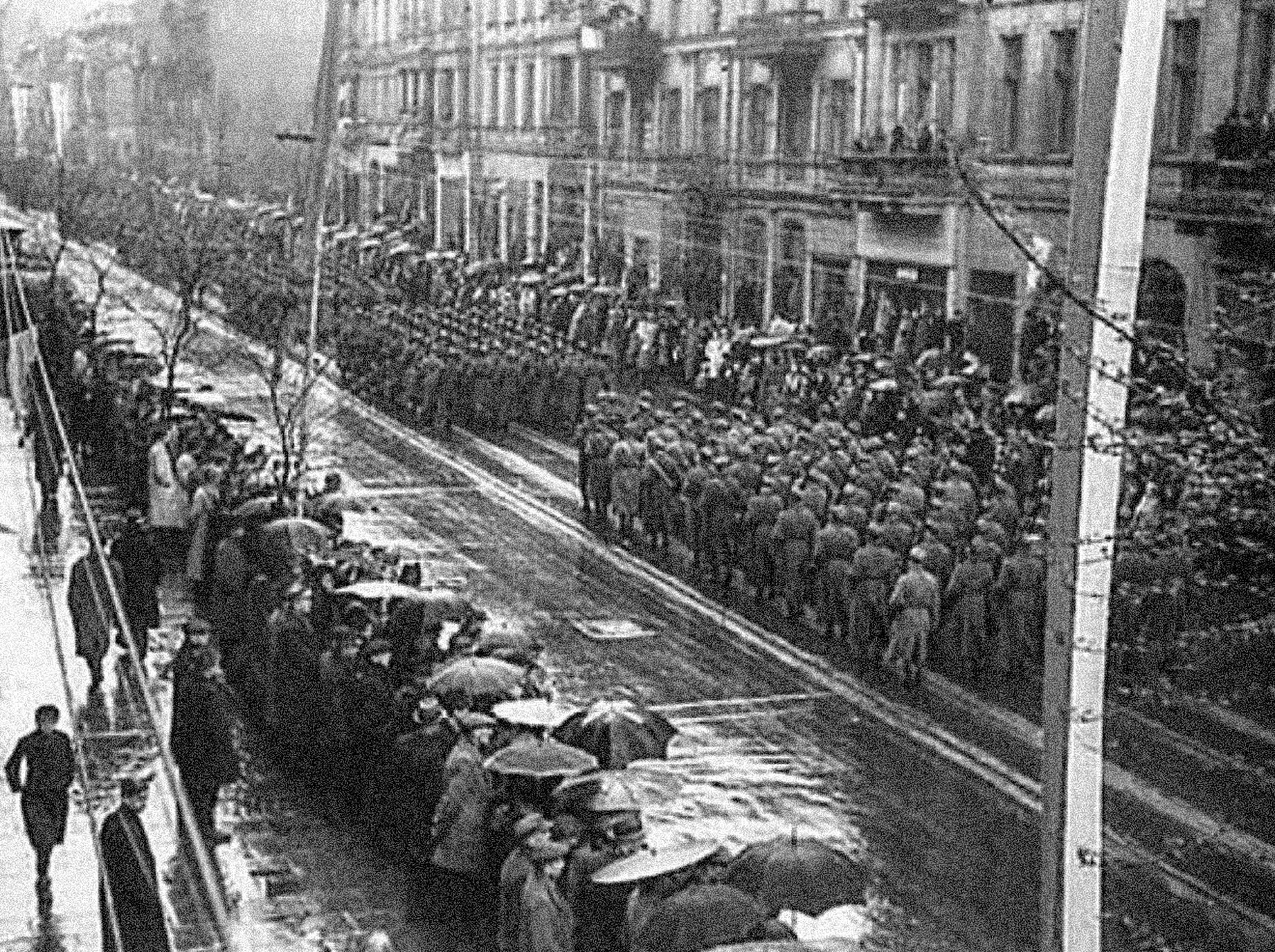 czarno białe zjecie przedstawiające wkraczających do łodzi żołnierzy radzieckich oraz przyglądający się tłum