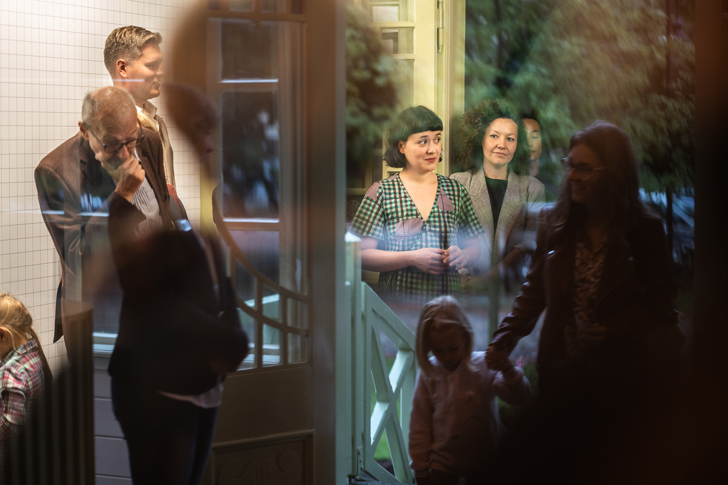 otwarcie wystawy, kilka osób odbijających się drzwiach willi