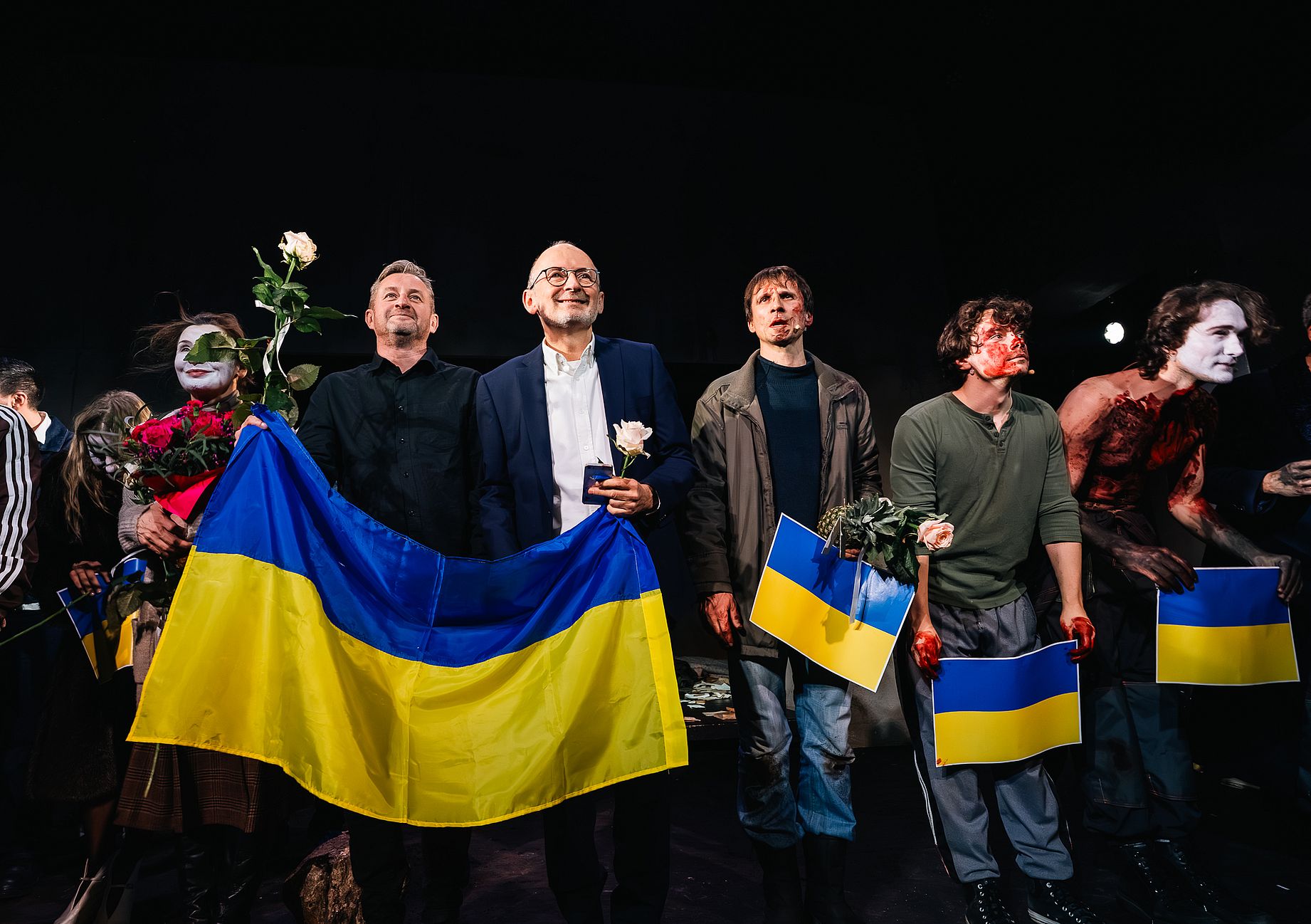 Scena w teatrze po spektaklu, aktorzy, reżyser, autor tekstu, Ukraińskie flagi