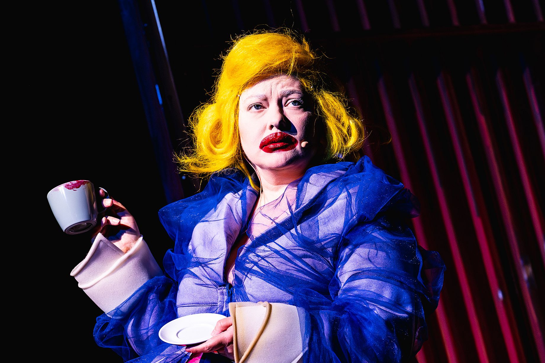 kobieta z przesadnym makijażem, żółte włosy, scena w teatrze