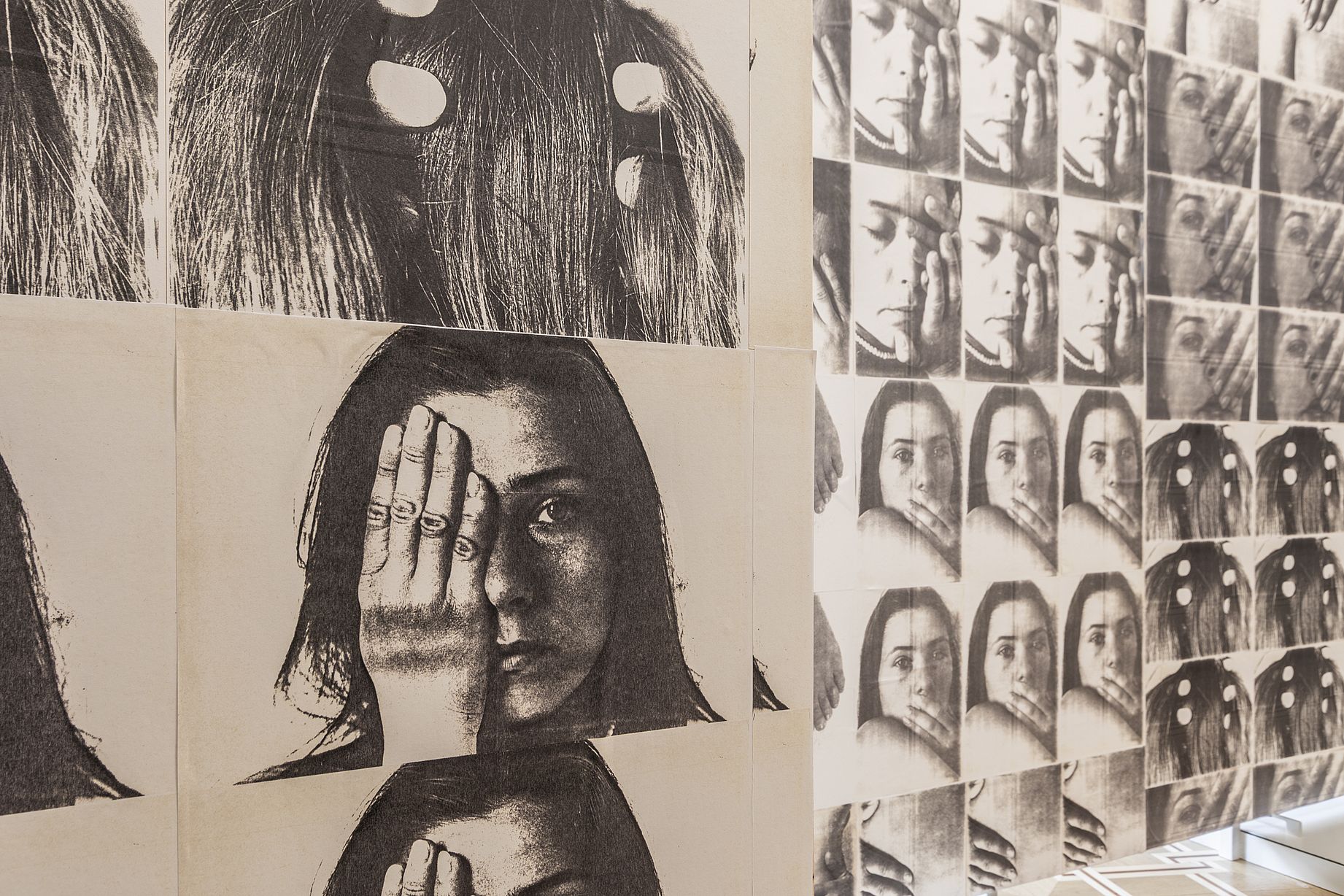 Widok wystawy, zdjęcie przedstawiające kobietę zakrywająca jedno oko