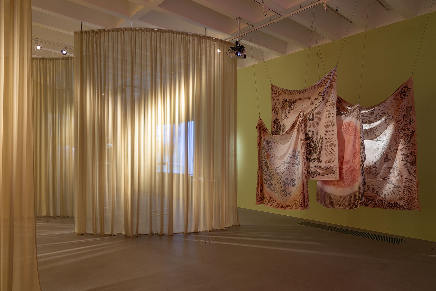 widok wystawy, kotra o raz tkaniny z orientalnymi wzorami, kolory żółte i pomarańczowe