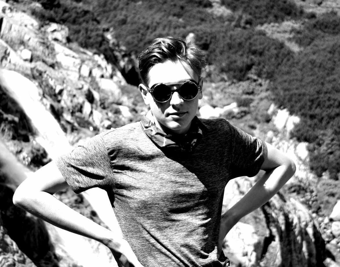 mężczyzna w okularach w górach