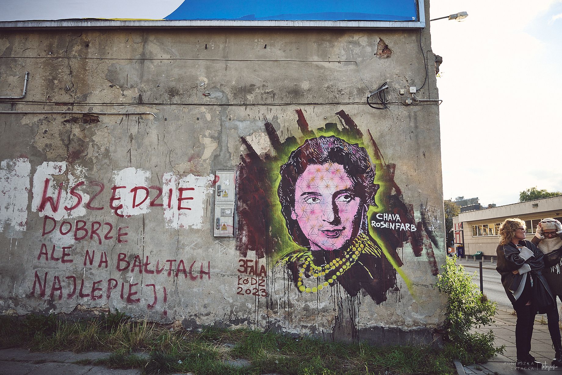 Zdęcie muralu Chavy Rosenfarb, na bałuckim rynku, obok ściany dwie kobiety