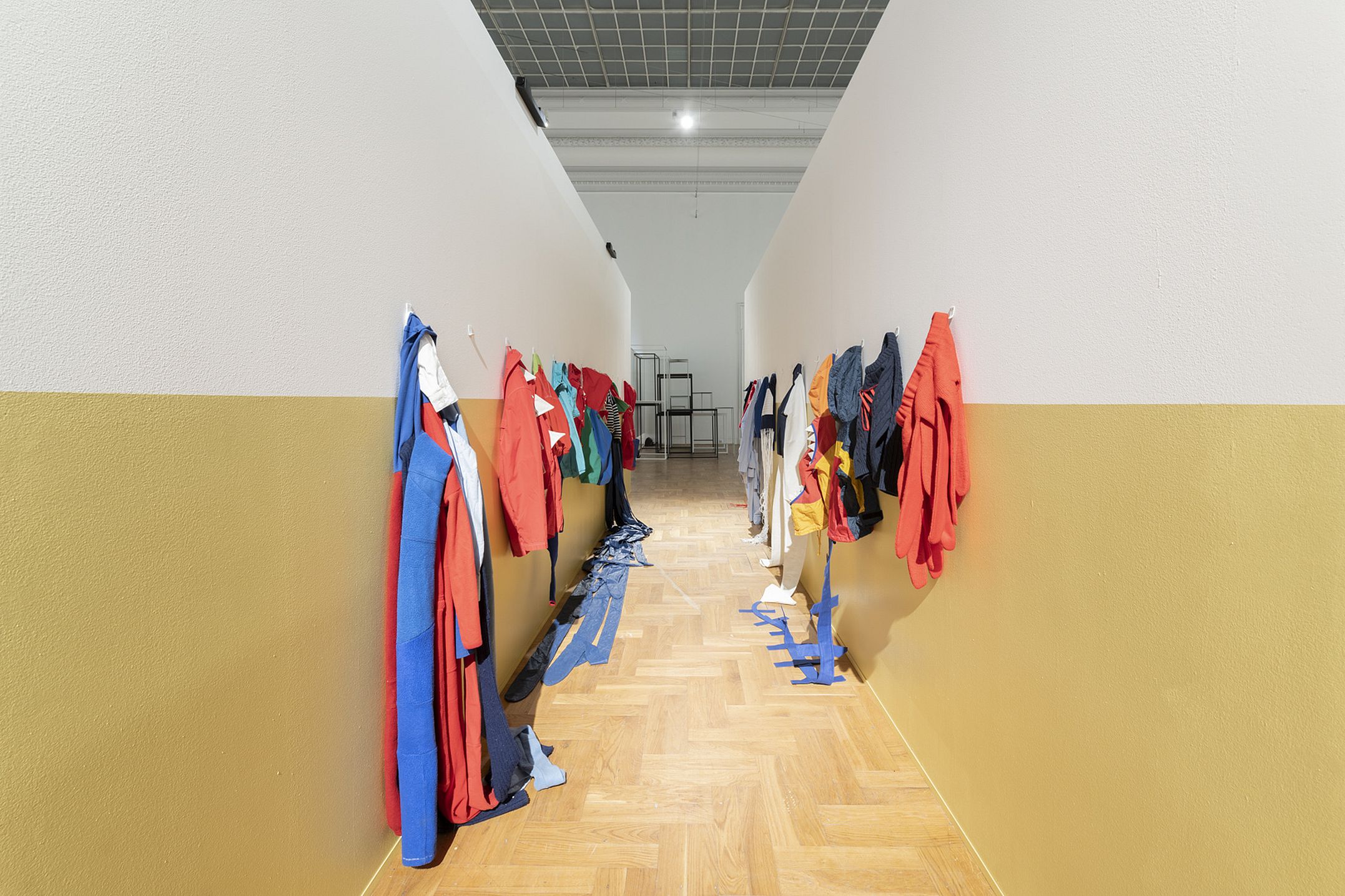 szkolny korytarz na wystawie, wiszą kurtki