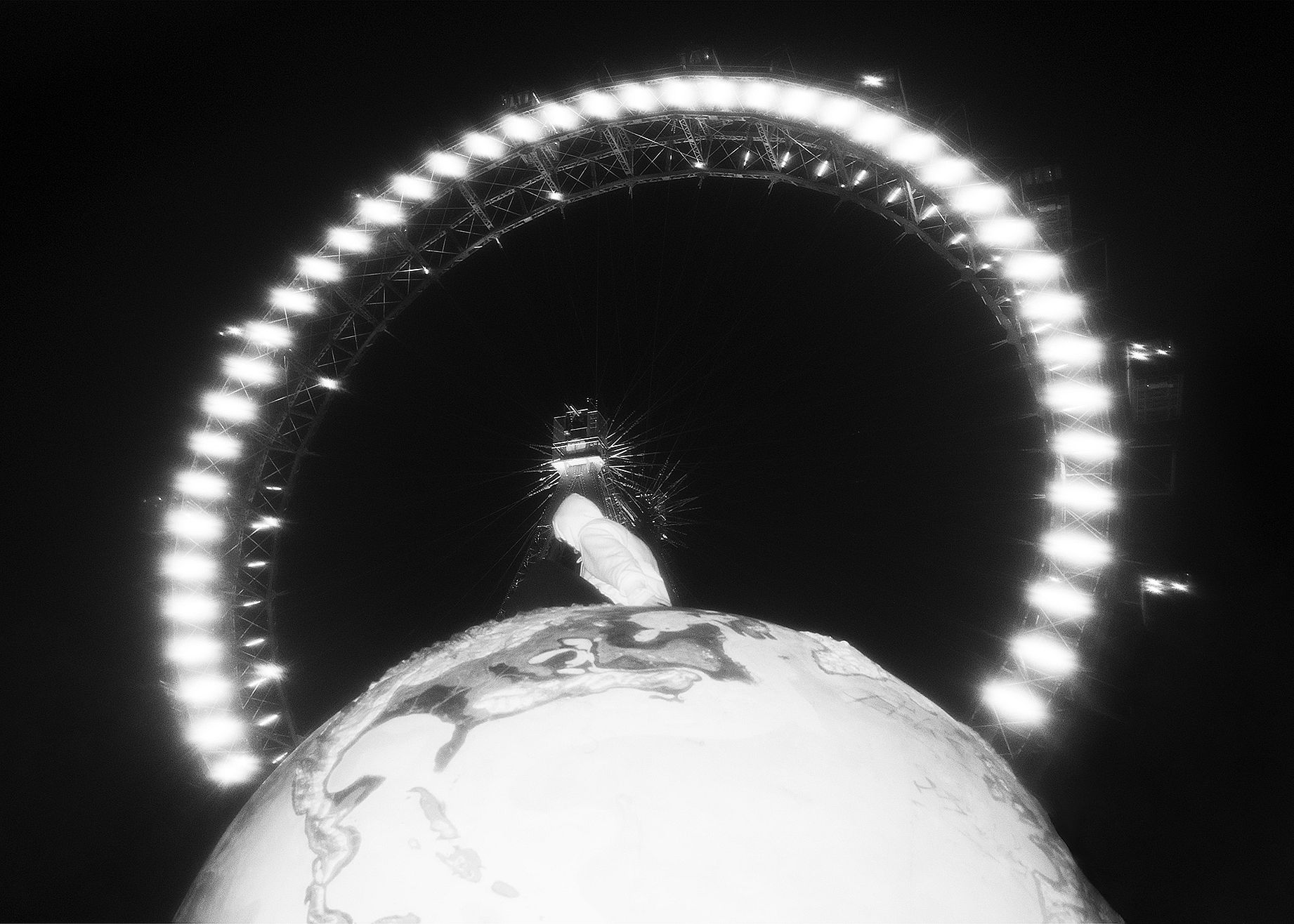 czarno białe zdjęcie z lunaparku, koło i człowiek