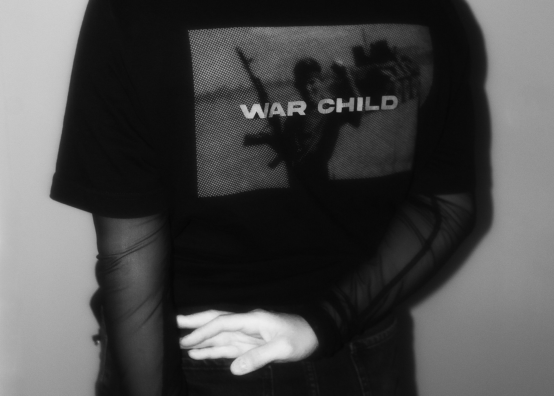 osoba wysunietą ręką z napisem War Child