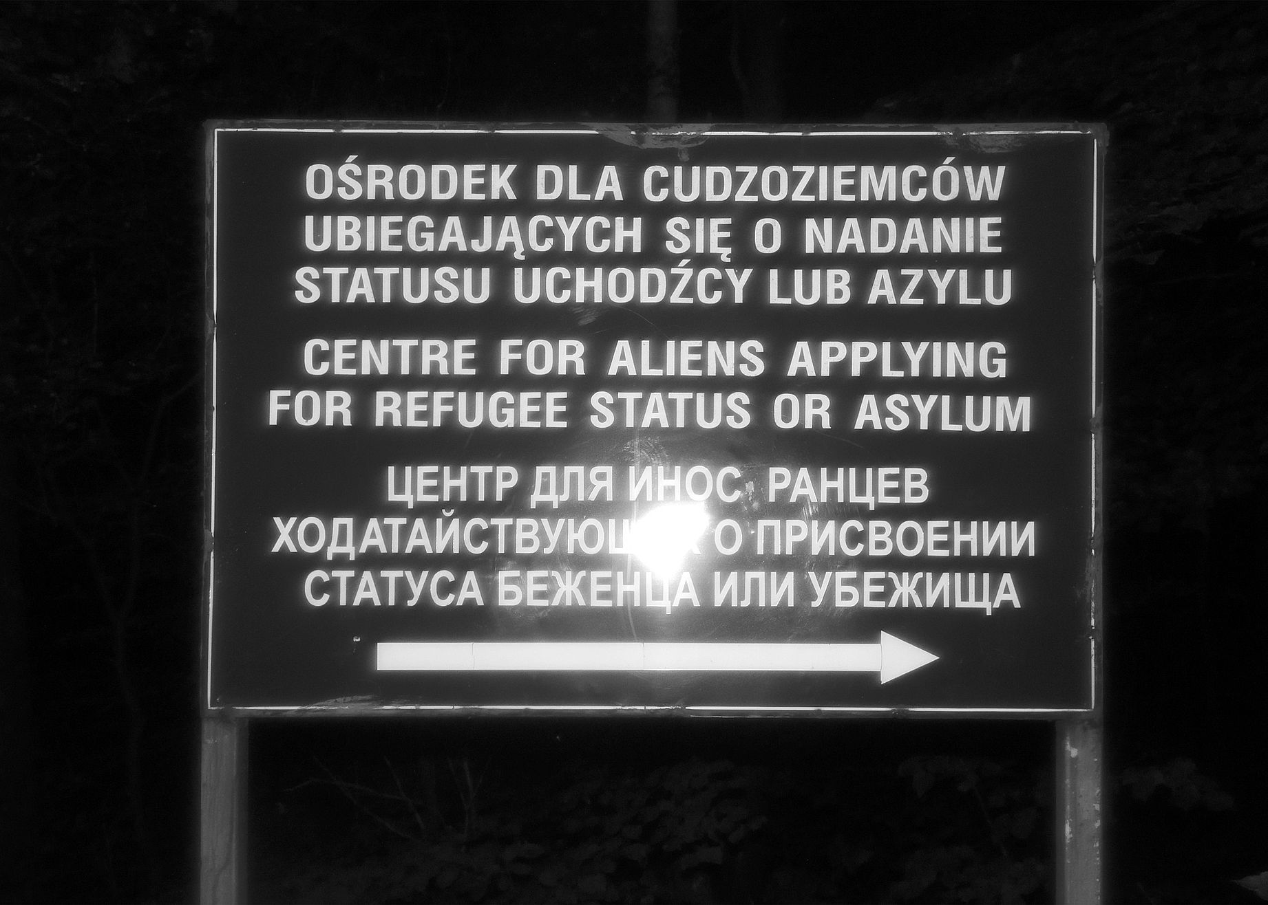 Czarno białe zdjęcie tablicy ośrodka dla uchodźców