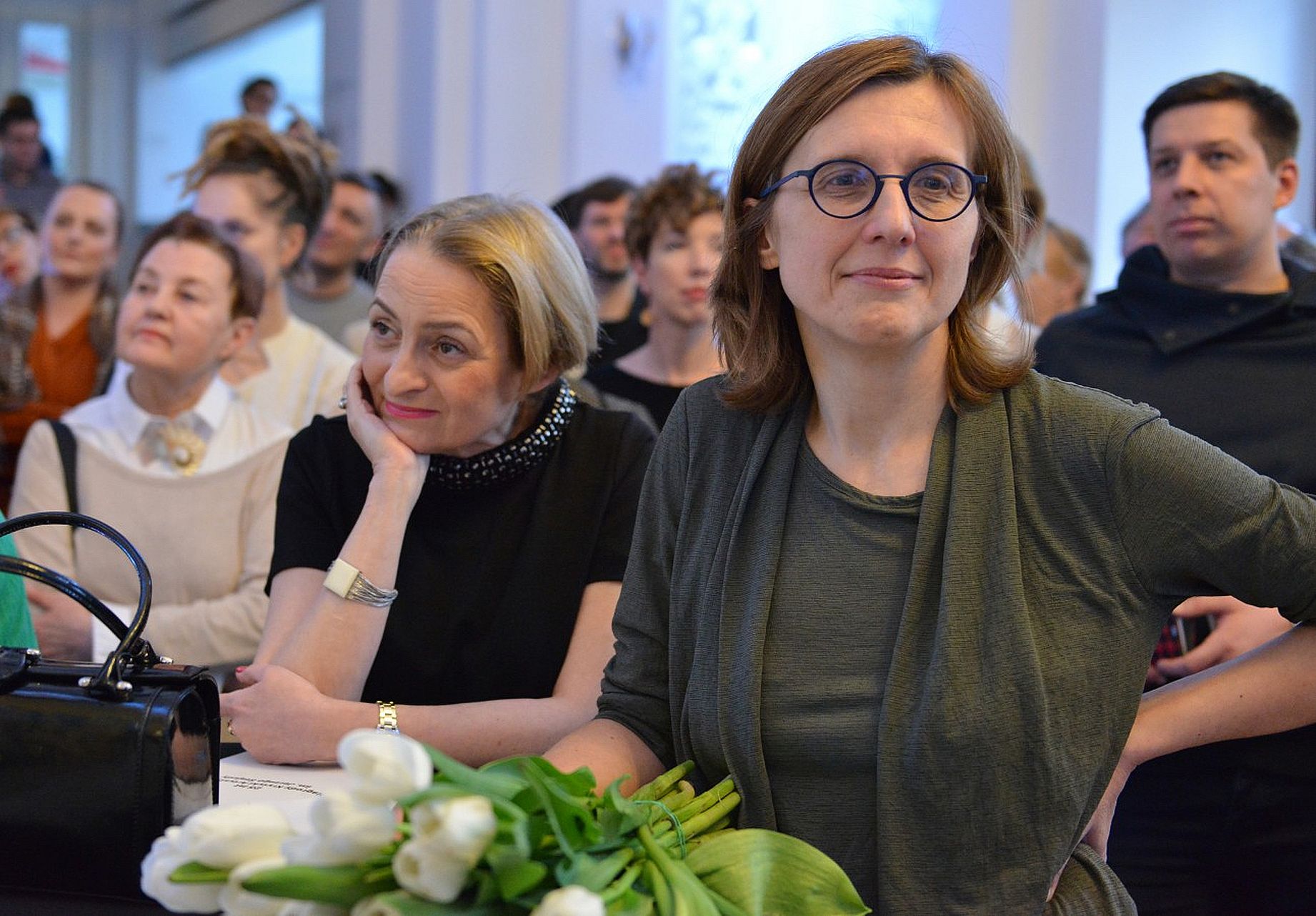 dwie kobiety siedzą przy stole podczas uroczystej gali